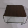 Salontafel chromen buisframe met een palisade/wit blad en glazen leg gedeelte en op wieltjes